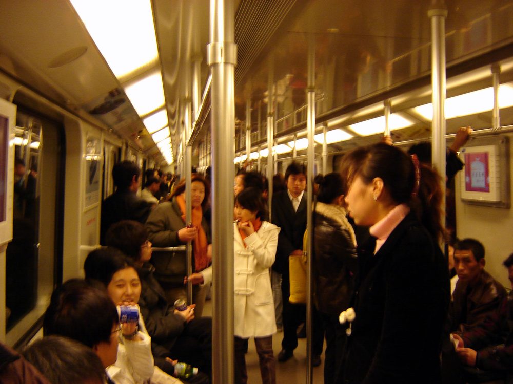 Spacious well-lit underground metro interchange concourse with clear bilingual directional signage