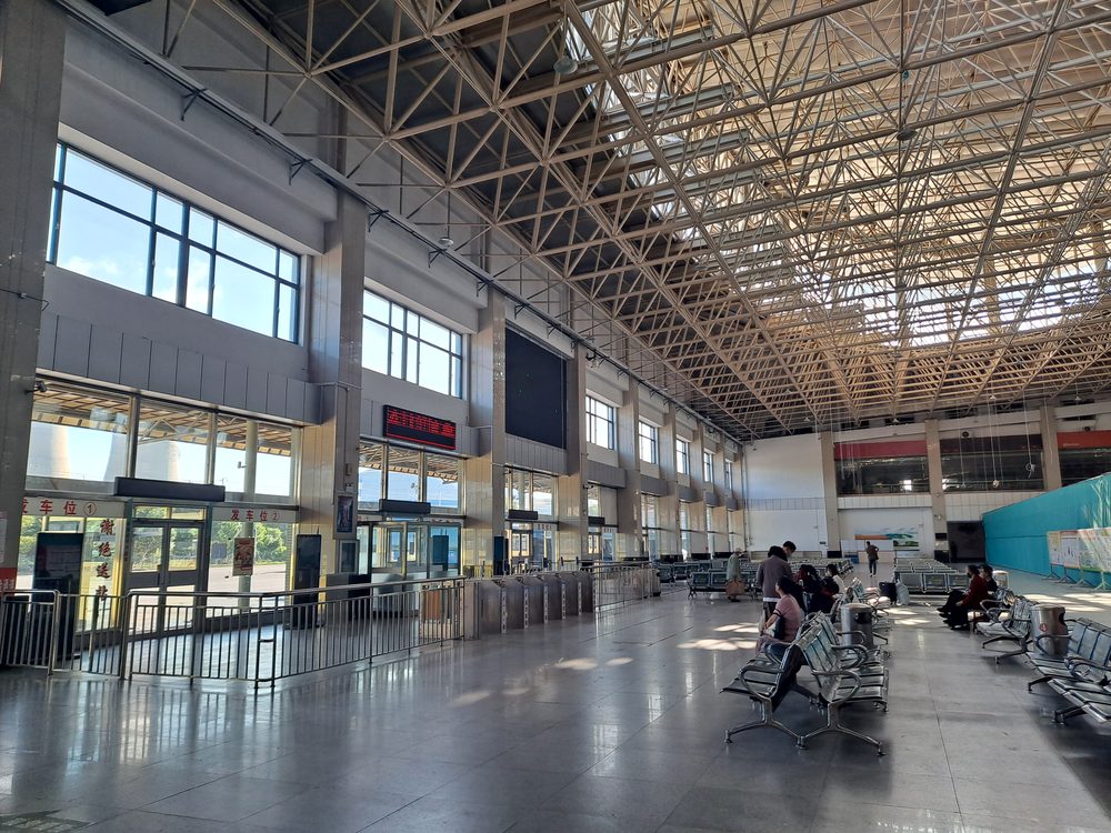 Hall d'embarquement d'une gare routière moderne en Chine avec portes d'accès numérotées vers les autocars