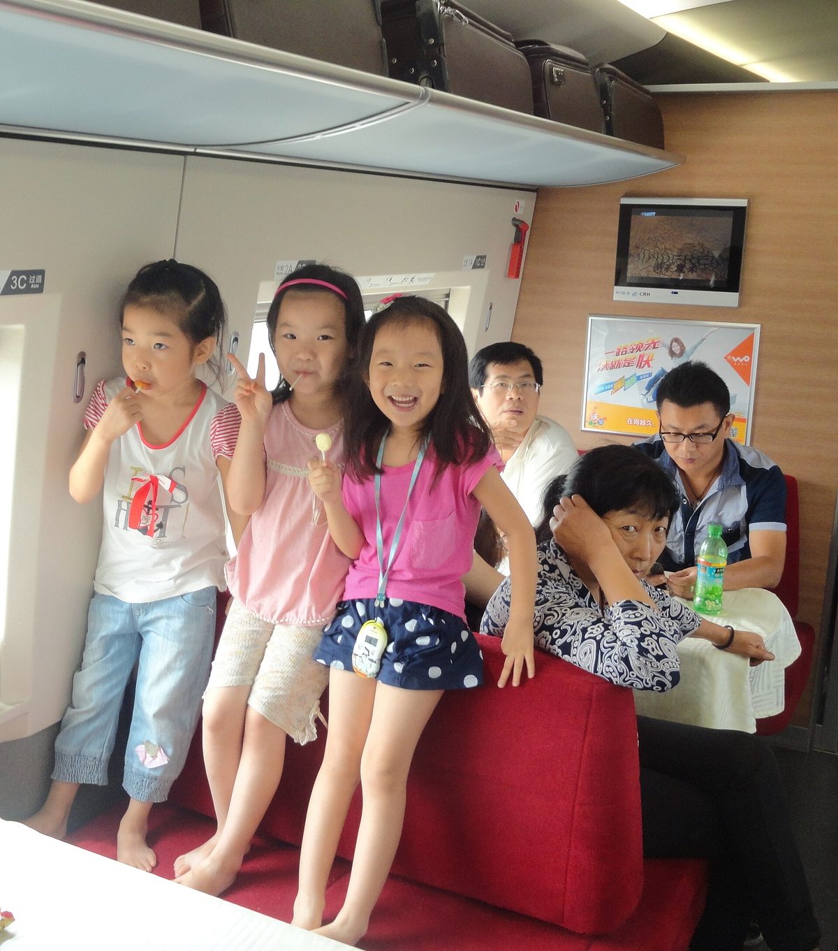 Train attendant handing freshly prepared warm local restaurant meal box directly to seated passenger on a modern Fuxing bullet train