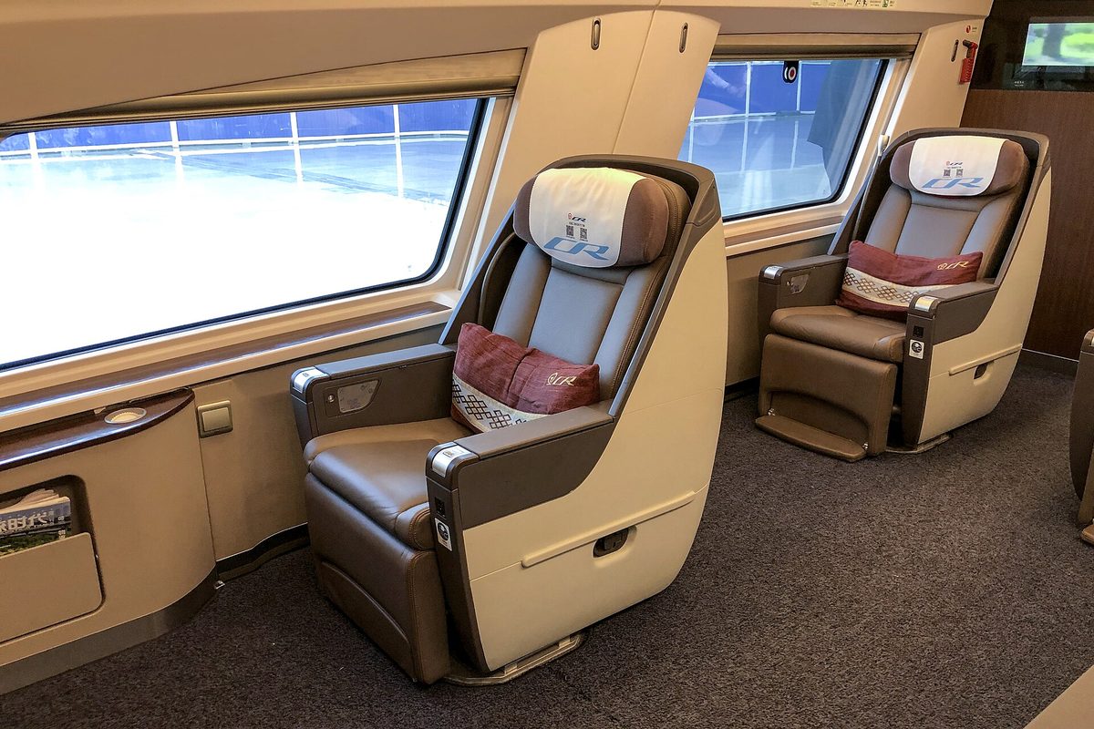 Modern Fuxing high-speed train cabin comparing spacious Second Class seating with First Class and private Business Class pods
