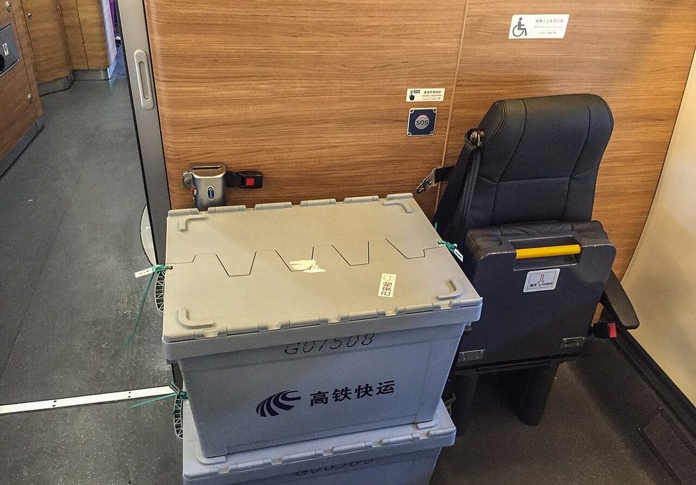 Famille voyageant avec un jeune enfant et une poussette pliée sur le quai d'un TGV en Chine