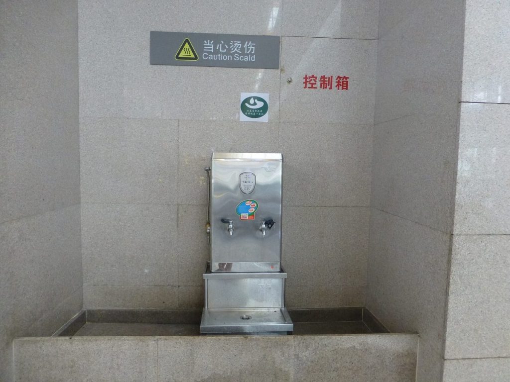 Modern stainless steel airport drinking water dispenser offering chilled warm and boiling water options with digital temperature display