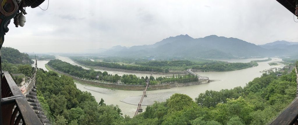 Sweeping panoramic view of the turquoise Min River surging through the ancient Fish Mouth water bypass at Dujiangyan