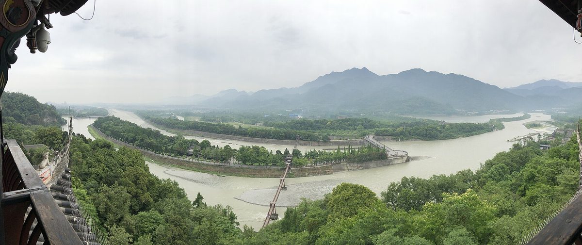 Sweeping panoramic view of the turquoise Min River surging through the ancient Fish Mouth water bypass at Dujiangyan