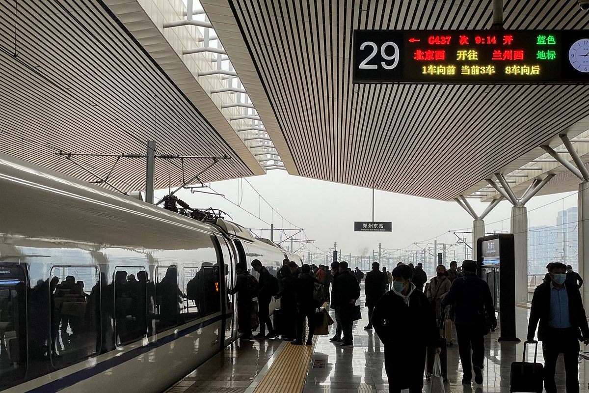 Modern high-speed bullet train speeding across the vast arid Hexi Corridor with snow-capped Qilian Mountains in the background