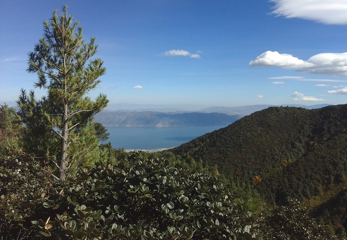 Breathtaking view of Erhai Lake in Dali with traditional Bai stone architecture and Cangshan Mountain range backdrop