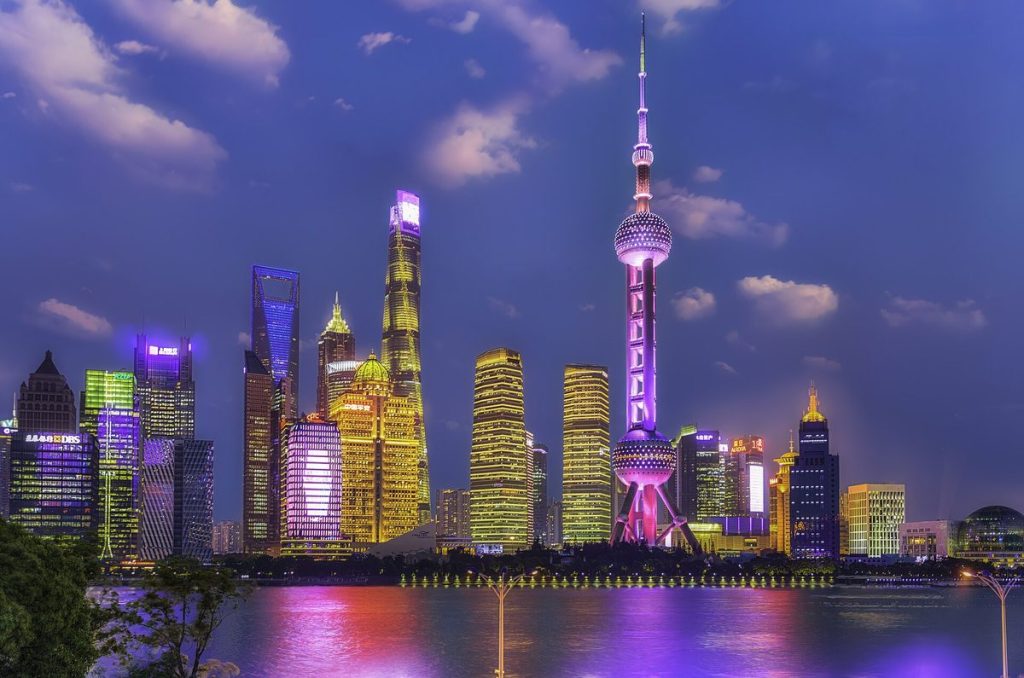 Iconic futuristic skyline of Pudong Lujiazui across the Huangpu River viewed from the historic Bund promenade at sunset