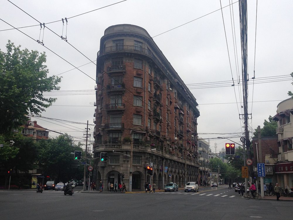 Leafy plane-tree shaded street lined with European Art Deco villas and trendy sidewalk cafes along Wukang Road in Shanghai
