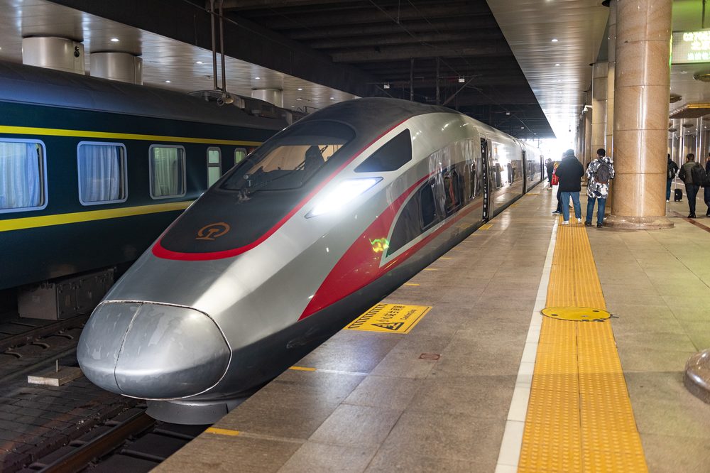 Sleek red and silver CR400AF Fuxing bullet train waiting for boarding along the clean passenger platform