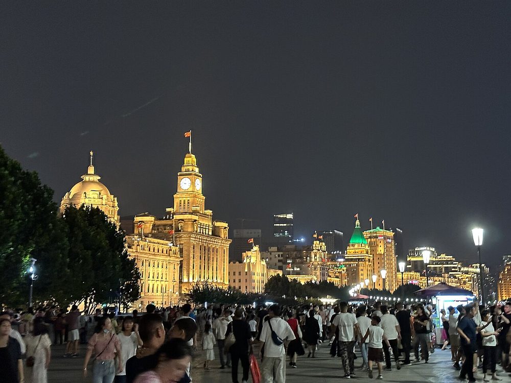 Illuminated historic European architecture along the Shanghai Bund waterfront promenade at night